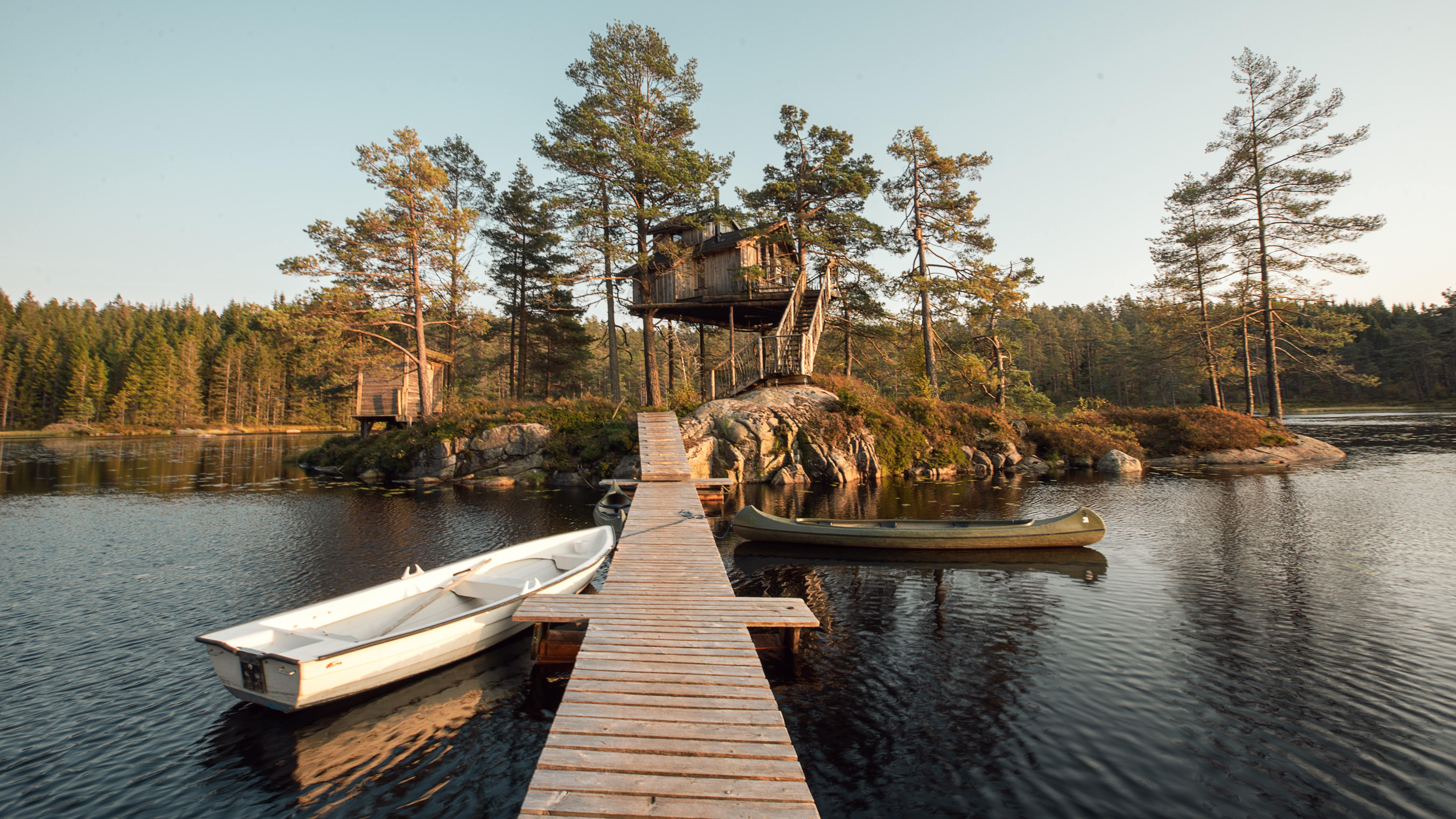 Trehytte i Sørlandet med brygge, robåt og kano